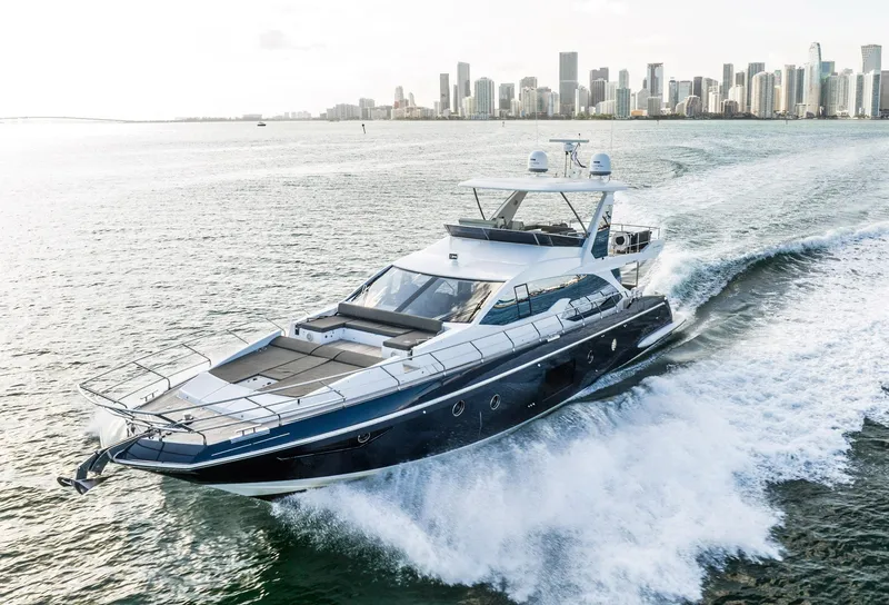 Slide: The Image of Luxury 2017 Azimut 66 yacht cruising near city skyline. - 1