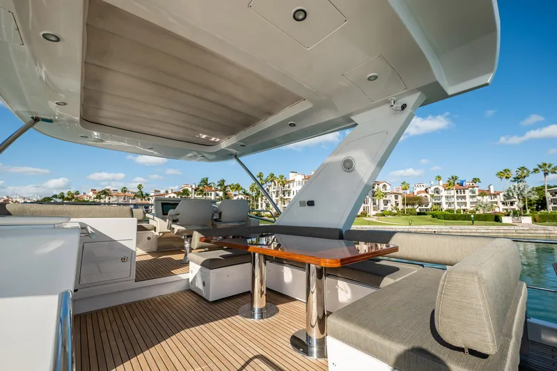 Slide: The Image of Luxurious 2017 Azimut 66 yacht deck with seating and table, overlooking waterfront homes. - 45