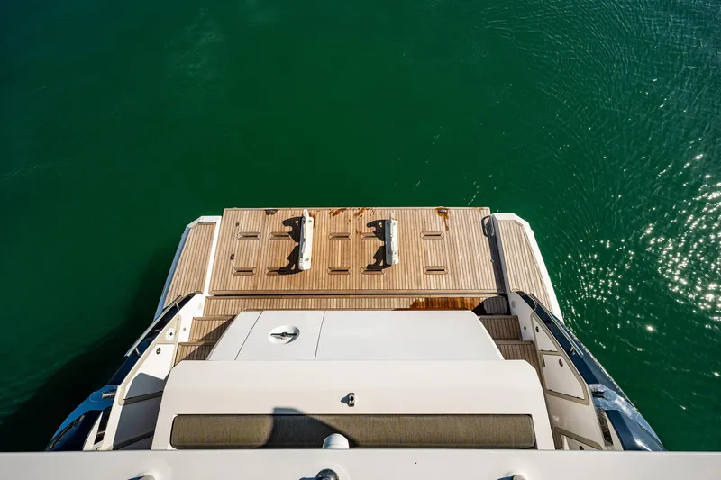 Slide: The Image of 2017 Azimut 66 yacht stern view with teak swim platform on calm water. - 49