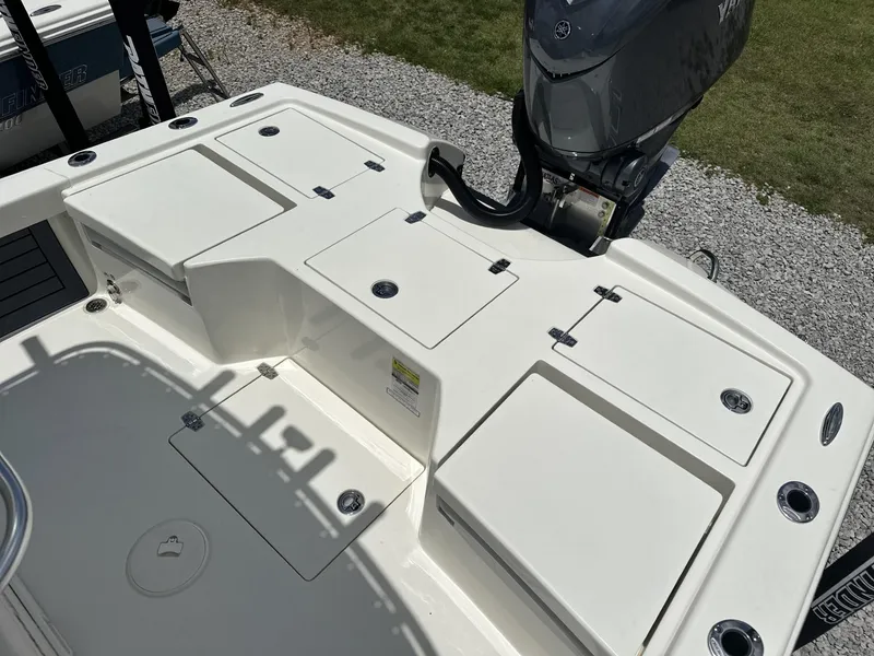Slide: The Image of 2025 Pathfinder 2500 Hybrid boat deck with storage compartments and outboard motor. - 2