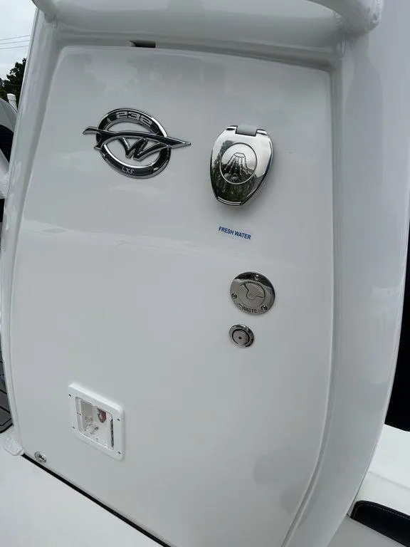 Slide: The Image of 2025 Tidewater 232 LXF boat detail with chrome fixtures and logo. - 14