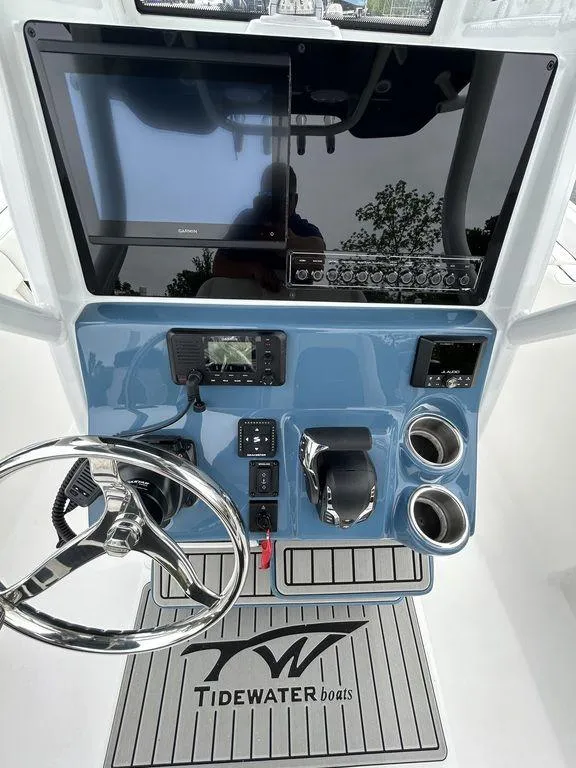 Slide: The Image of 2025 Tidewater 232 LXF boat dashboard with steering wheel and electronic controls. - 9
