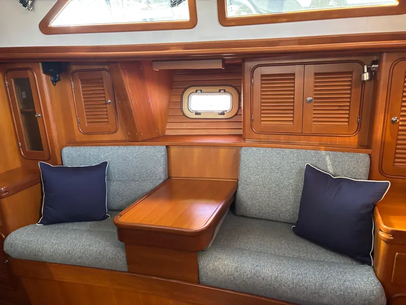 Slide: The Image of Cozy interior of 2004 Passport 470 yacht with wooden finish and cushioned seating. - 15