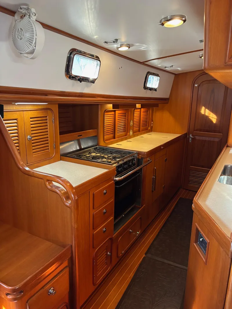 Slide: The Image of Luxurious wooden interior of a 2004 Passport 470 yacht kitchen with stove and cabinets. - 16
