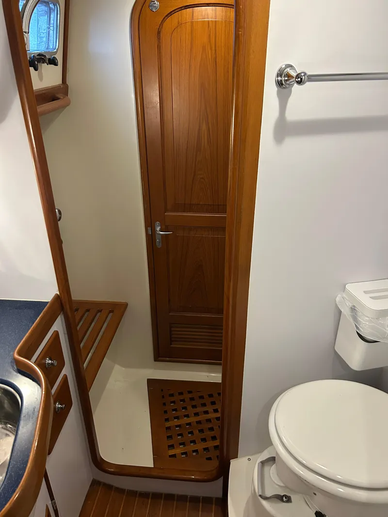 Slide: The Image of 2004 Passport 470 yacht bathroom with wooden door, sink, and toilet. - 24