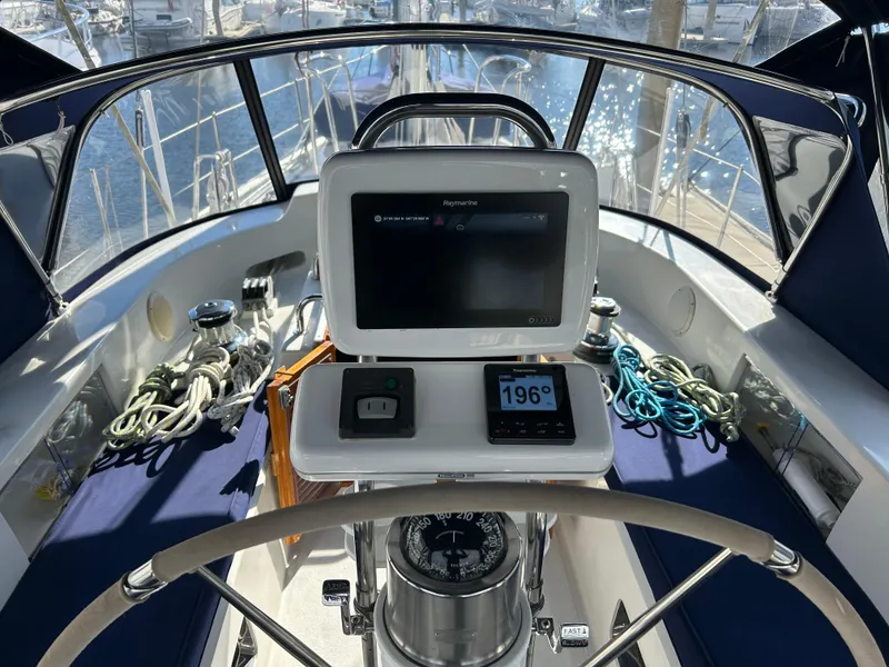 Slide: The Image of Cockpit of 2004 Passport 470 sailboat with navigation equipment and steering wheel. - 26
