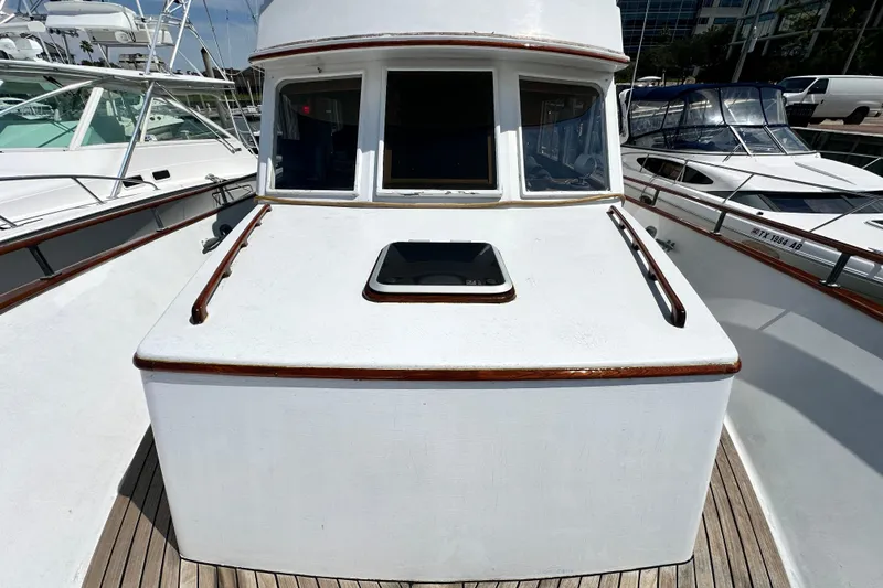 Slide: The Image of 1980 Island Gypsy Flush Aft Deck Trawler-Motor Yacht, docked with visible deck and windows. - 10