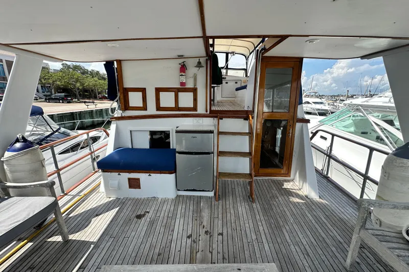 Slide: The Image of 1980 Island Gypsy Flush Aft Deck Trawler-Motor Yacht, featuring wooden deck and seating area. - 15