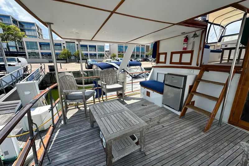 Slide: The Image of 1980 Island Gypsy Flush Aft Deck Trawler-Motor Yacht with wooden deck and seating area. - 16