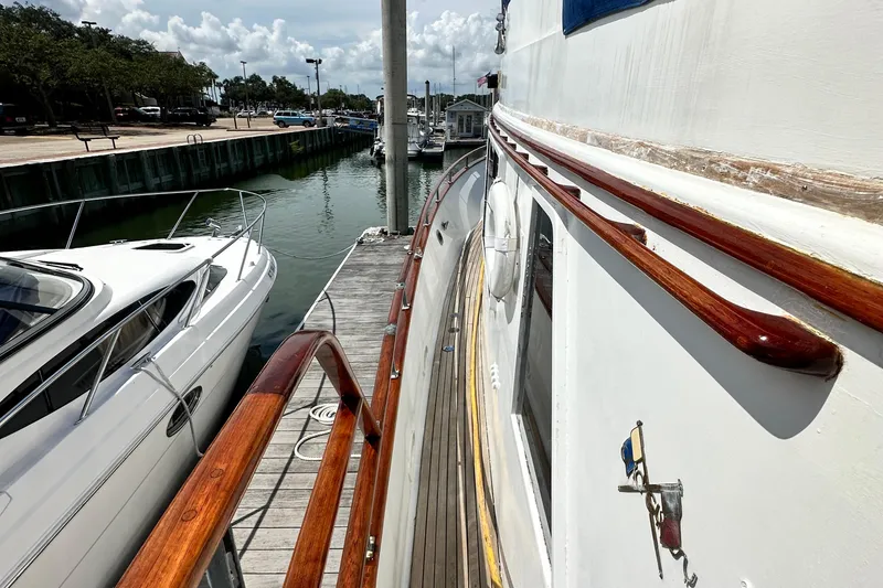Slide: The Image of 1980 Island Gypsy Flush Aft Deck Trawler-Motor Yacht docked beside another boat. - 18