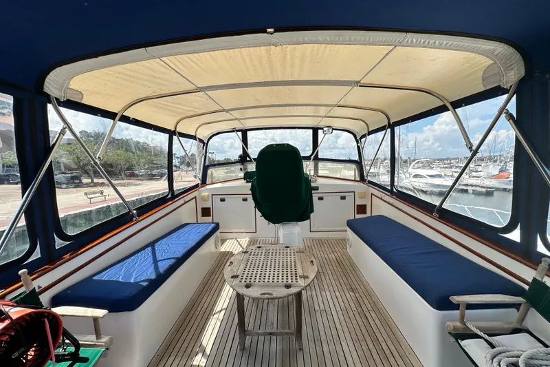 Slide: The Image of 1980 Island Gypsy Flush Aft Deck Trawler-Motor Yacht interior with blue seating and wooden table. - 20