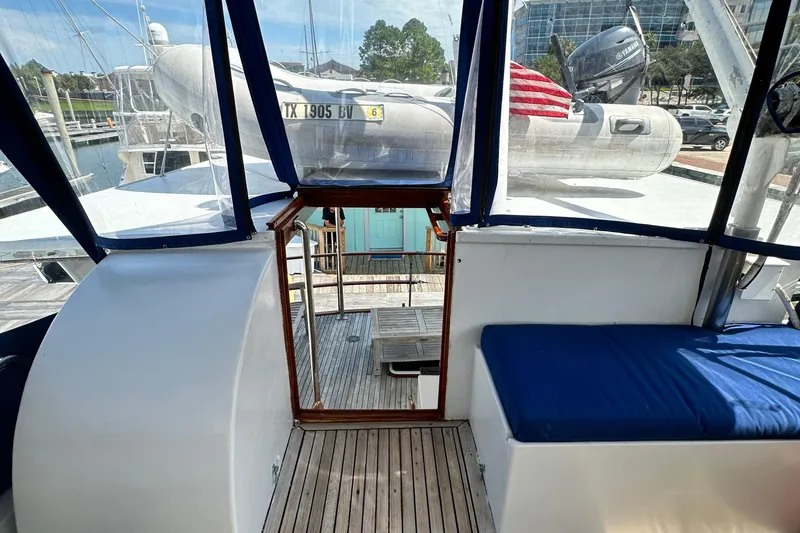 Slide: The Image of 1980 Island Gypsy Flush Aft Deck Trawler-Motor Yacht interior with blue seating and wooden flooring. - 27