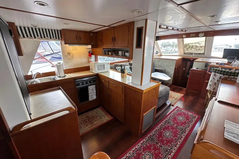 Slide: The Image of 1980 Island Gypsy Flush Aft Deck Trawler-Motor Yacht interior with kitchen and seating area. - 29