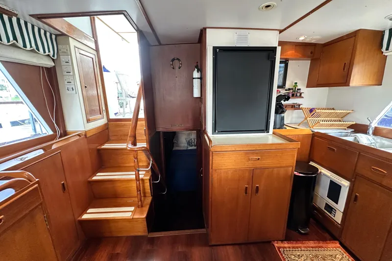 Slide: The Image of Interior of 1980 Island Gypsy Flush Aft Deck Trawler-Motor Yacht with wooden cabinetry and stairs. - 36