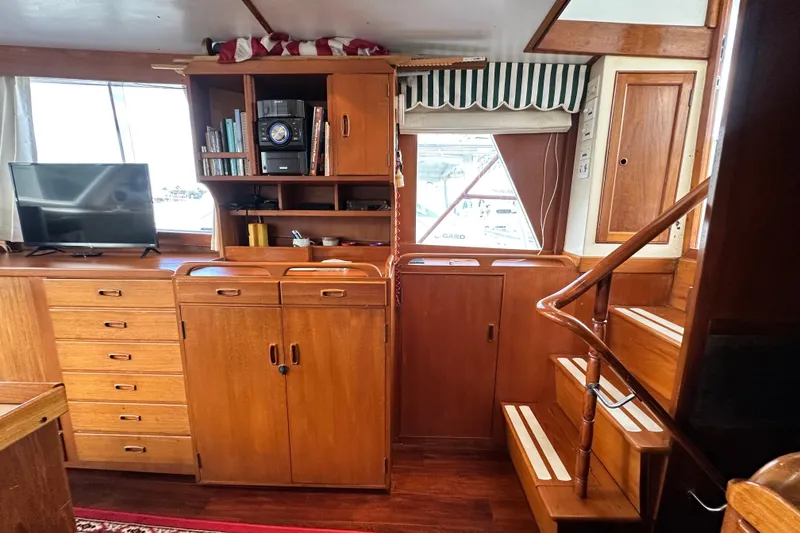 Slide: The Image of Interior of 1980 Island Gypsy Flush Aft Deck Trawler-Motor Yacht with wooden cabinetry and stairs. - 37