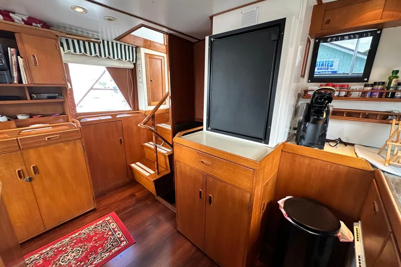 Slide: The Image of 1980 Island Gypsy yacht interior with wooden cabinetry, stairs, and kitchen area. - 42