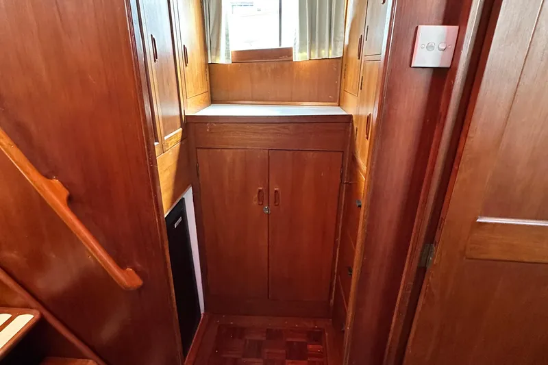 Slide: The Image of 1980 Island Gypsy Flush Aft Deck Trawler-Motor Yacht interior with wooden cabinetry and stairs. - 57