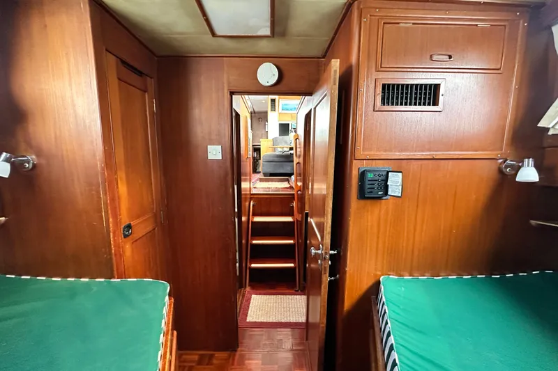 Slide: The Image of Interior of 1980 Island Gypsy Flush Aft Deck Trawler-Motor Yacht with wooden paneling and green bedding. - 60