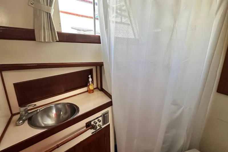Slide: The Image of 1980 Island Gypsy yacht bathroom with sink, faucet, and shower curtain. - 61