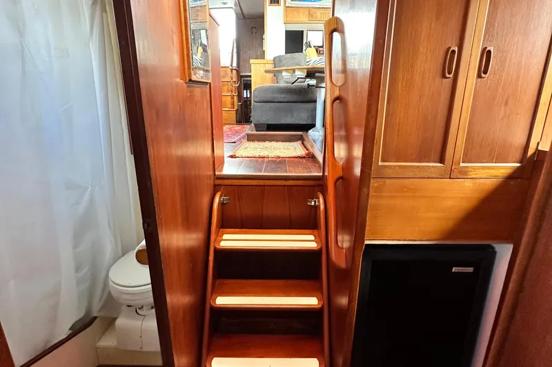 Slide: The Image of Interior of 1980 Island Gypsy Flush Aft Deck Trawler-Motor Yacht with wooden stairs and cabinetry. - 63
