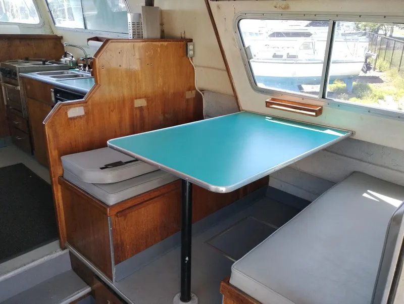 Slide: The Image of 1996 Martin Trunk Cabin interior with turquoise table, wooden cabinetry, and seating. - 12