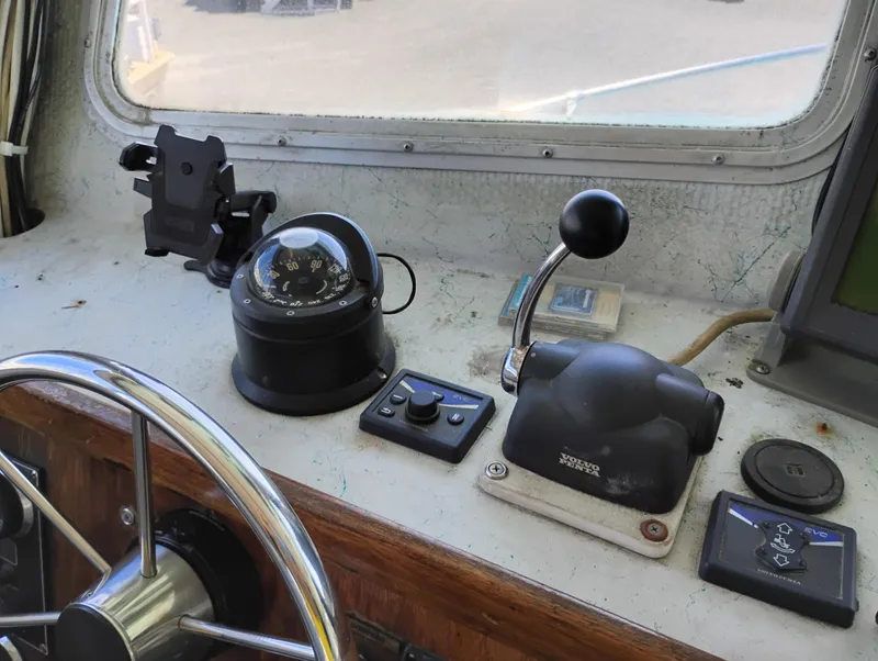 Slide: The Image of 1996 Martin Trunk Cabin boat dashboard with steering wheel, compass, and throttle controls. - 20