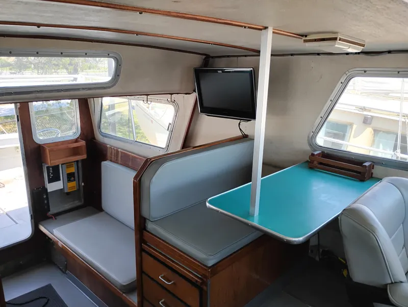 Slide: The Image of Interior of a 1996 Martin Trunk Cabin boat with seating, table, and TV. - 29