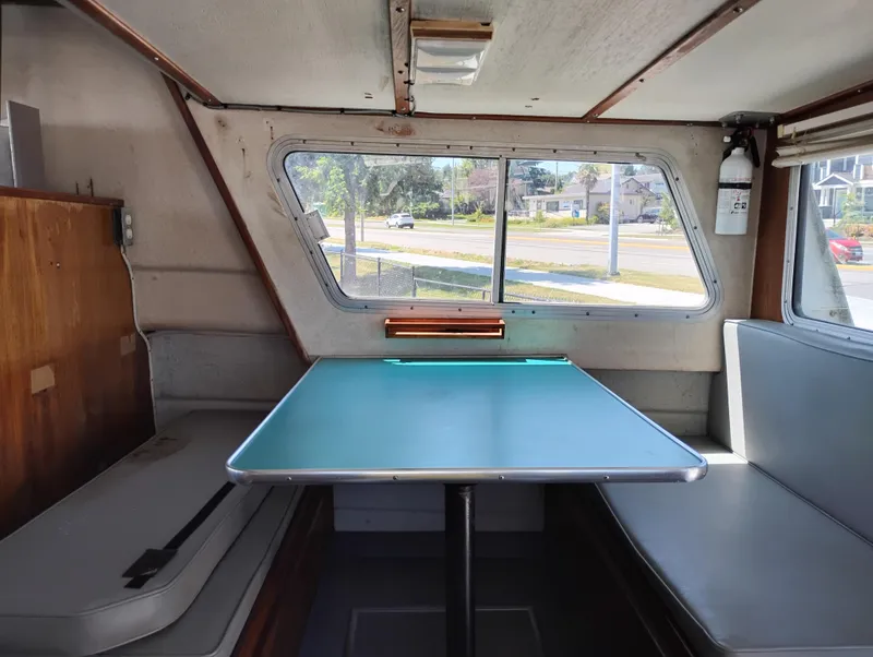 Slide: The Image of Interior of a 1996 Martin Trunk Cabin with a teal table and seating. - 32