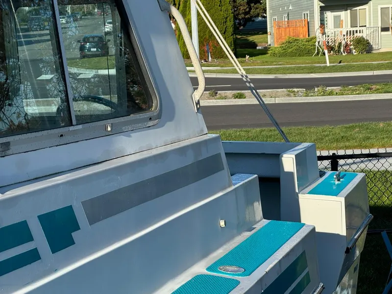 Slide: The Image of 1996 Martin Trunk Cabin boat with blue accents, parked near a residential area. - 4