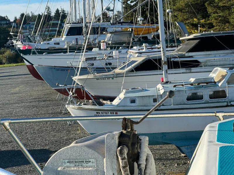 Slide: The Image of Boats docked on land, including a 1996 Martin Trunk Cabin, in a marina setting. - 5