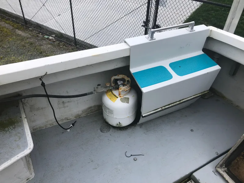 Slide: The Image of 1996 Martin Trunk Cabin boat interior with propane tank and seating. - 9