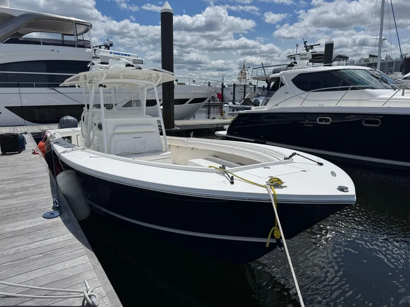 The Image of 2014 Regulator 34 Center Console boat docked at marina under cloudy sky. - 1