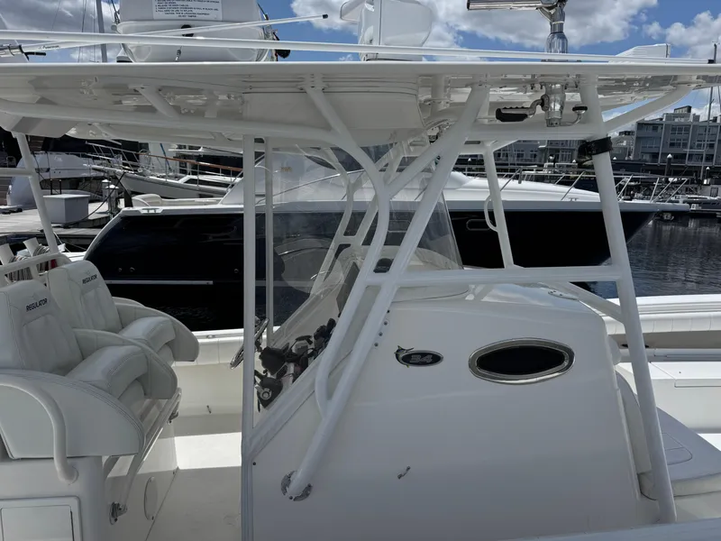 Slide: The Image of 2014 Regulator 34 Center Console boat with white seating and helm, docked at a marina. - 3