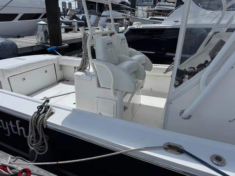 Slide: The Image of 2014 Regulator 34 Center Console boat docked, featuring white seating and clean deck. - 4