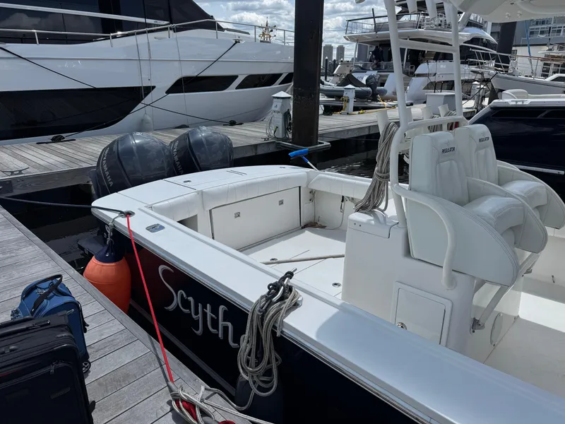 Slide: The Image of 2014 Regulator 34 Center Console boat docked at marina with visible seating and equipment. - 5