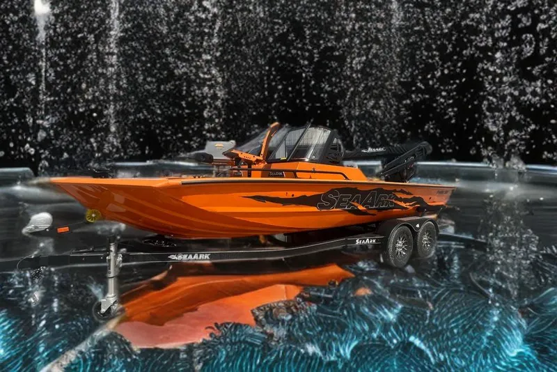 Slide: The Image of 2026 SeaArk ProCat 200 boat in vibrant orange on a trailer, parked in a snowy area. - 10