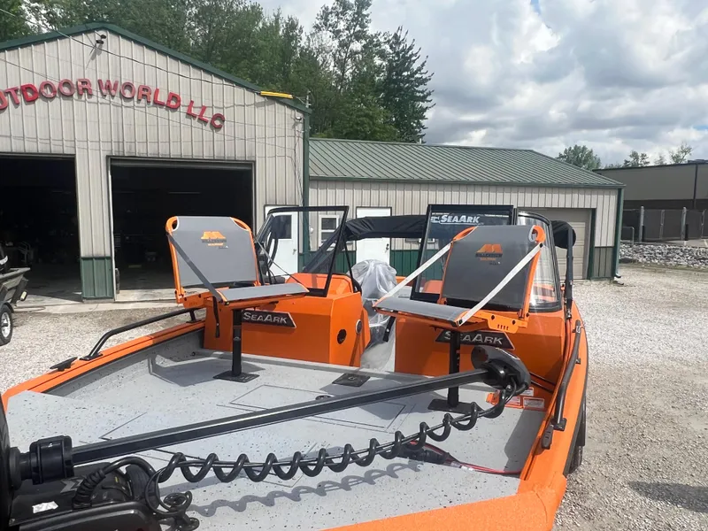 Slide: The Image of 2025 SeaArk ProCat 200 boat with orange accents and two gray seats in a dealership lot. - 4