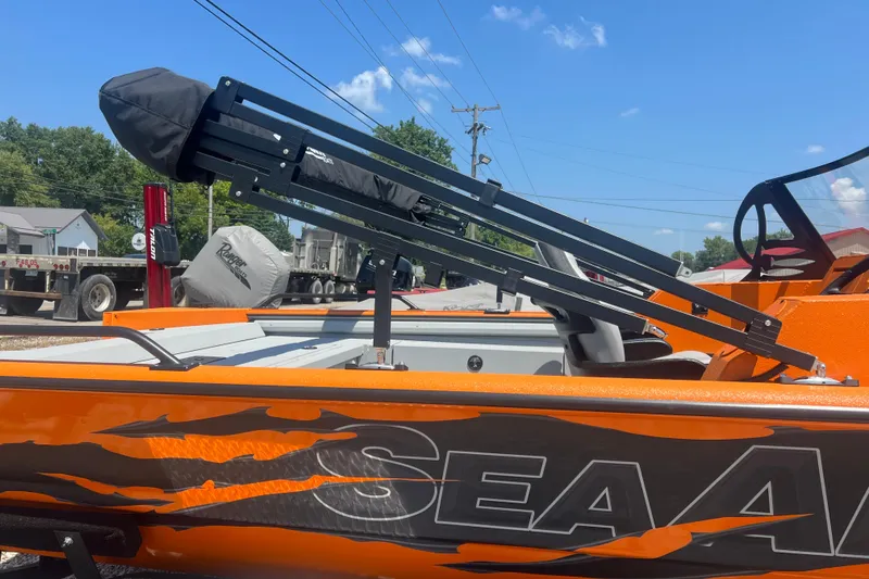 Slide: The Image of 2026 SeaArk ProCat 200 boat in vibrant orange, parked on a trailer in a snowy lot. - 8