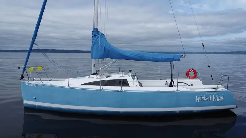 Slide: The Image of 2015 Catalina 275 Sport sailboat on calm water, blue hull, overcast sky. - 15