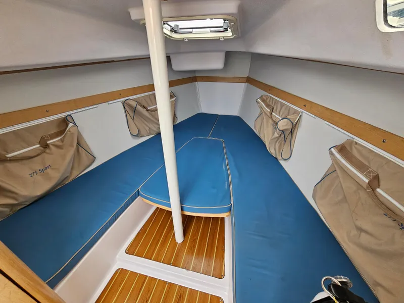 Slide: The Image of 2015 Catalina 275 Sport cabin interior with blue cushions and wooden flooring. - 5