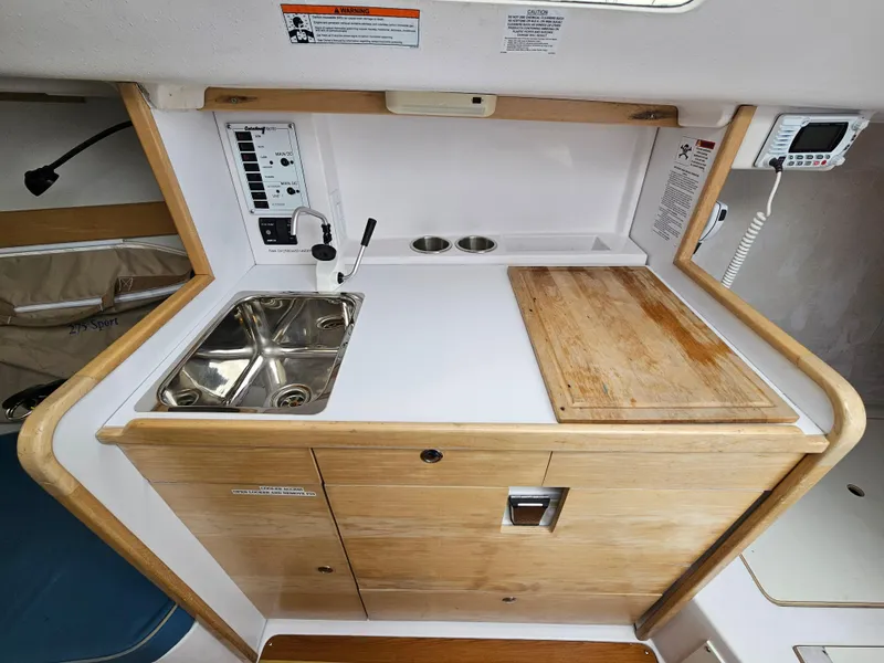 Slide: The Image of Compact kitchen area in a 2015 Catalina 275 Sport sailboat with sink and wooden countertop. - 6
