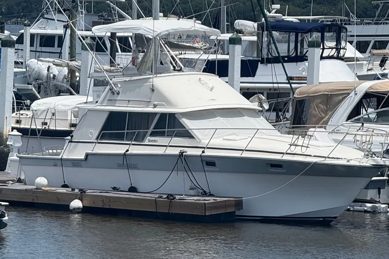 Slide: The Image of 1986 Silverton 34 Convertible Flybridge yacht docked at marina. - 0