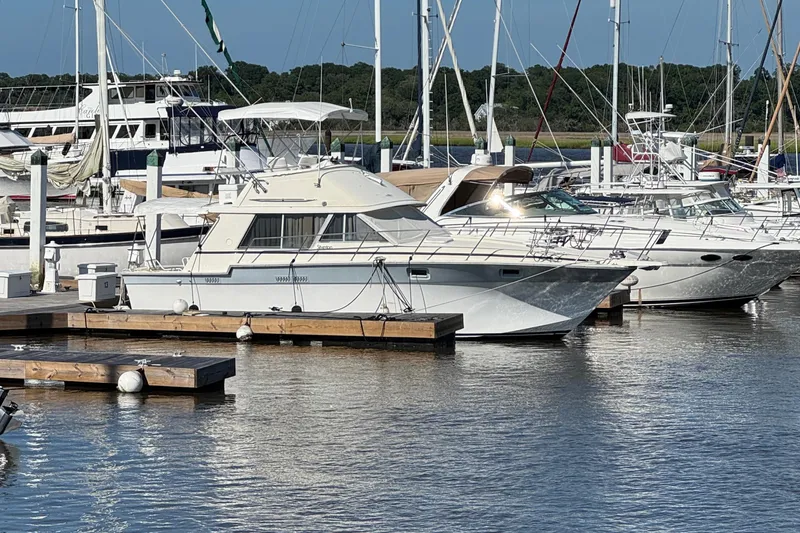 Slide: The Image of 1986 Silverton 34 Convertible Flybridge docked in a marina with other boats. - 1