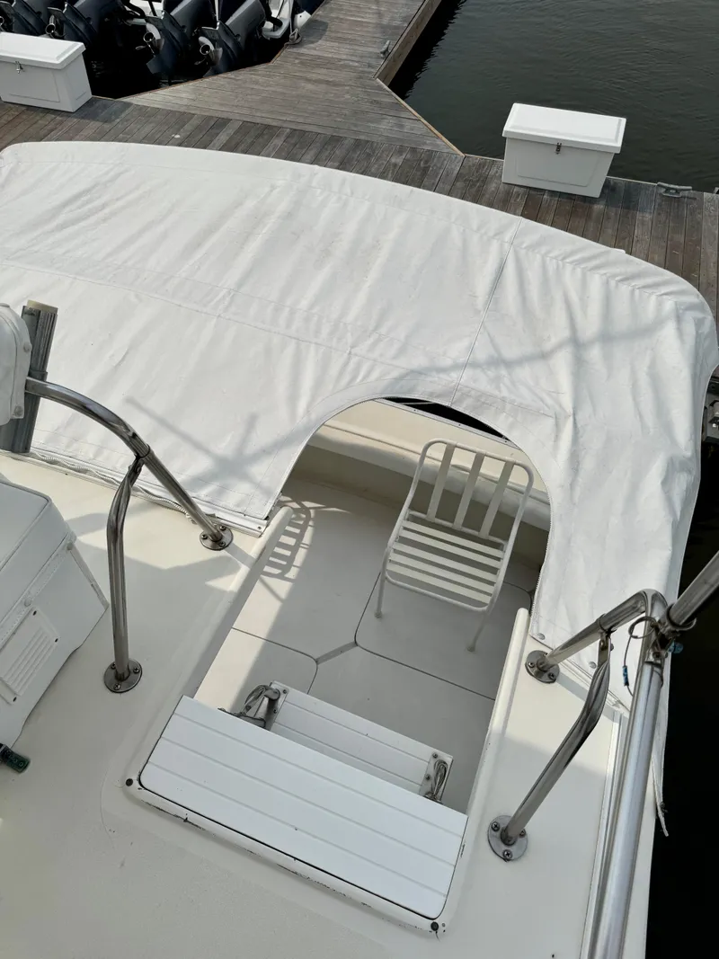 Slide: The Image of 1986 Silverton 34 Convertible Flybridge with covered seating area at dock. - 10