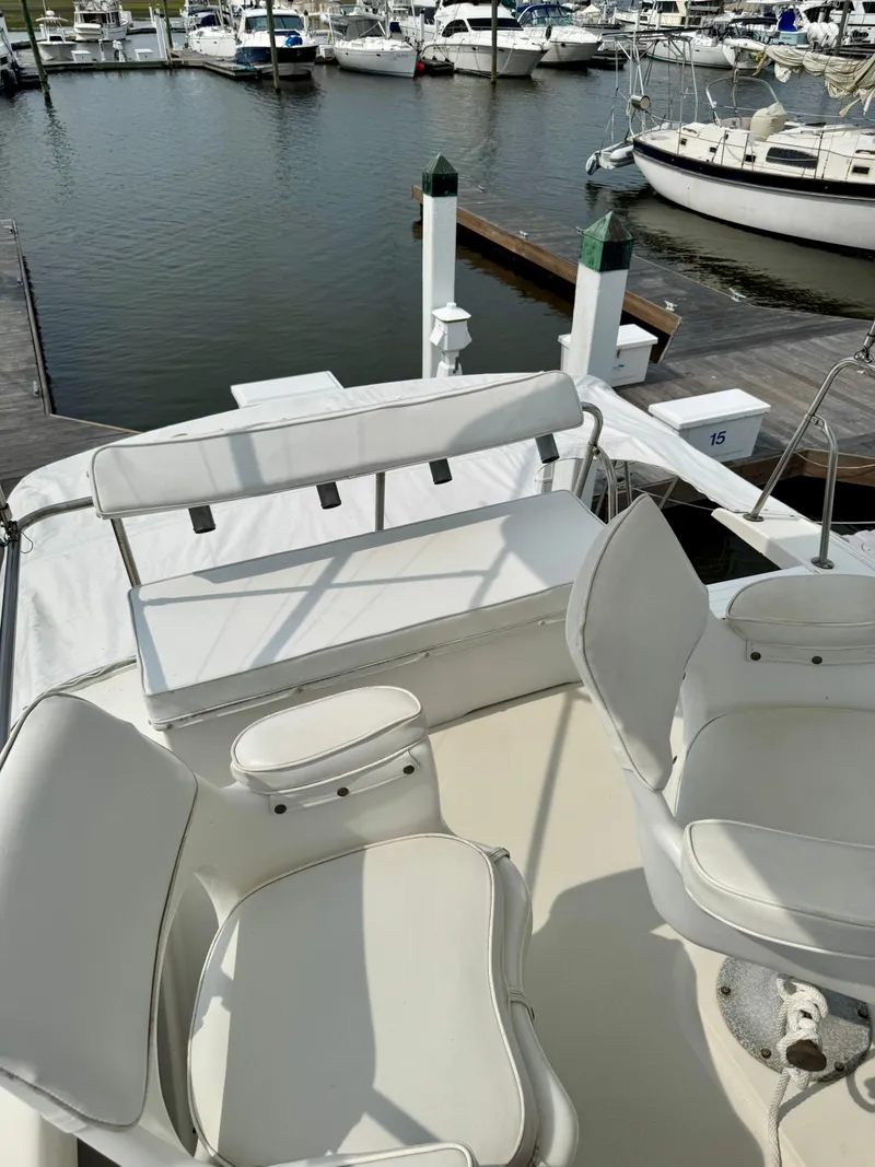 Slide: The Image of 1986 Silverton 34 Convertible Flybridge with white seating, docked at a marina. - 13