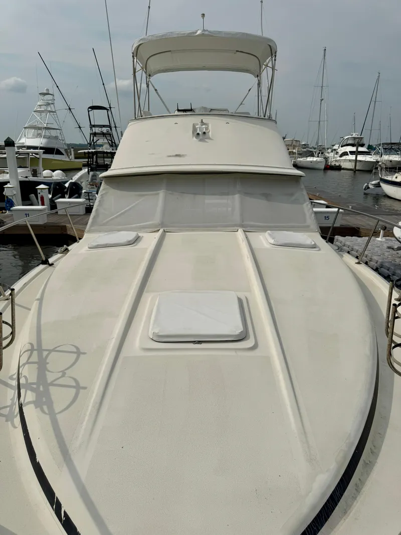 Slide: The Image of 1986 Silverton 34 Convertible Flybridge yacht docked at a marina. - 16