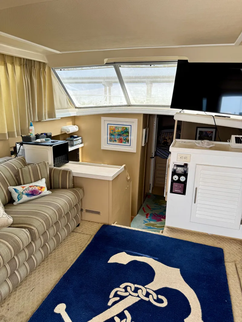 Slide: The Image of 1986 Silverton 34 Convertible Flybridge interior with striped sofa, nautical decor, and modern amenities. - 19