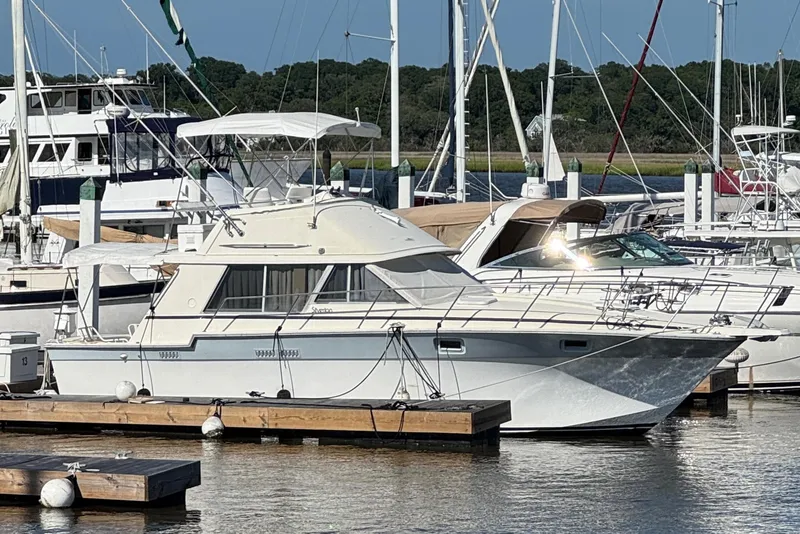 Slide: The Image of 1986 Silverton 34 Convertible Flybridge docked at a marina, surrounded by other boats. - 2