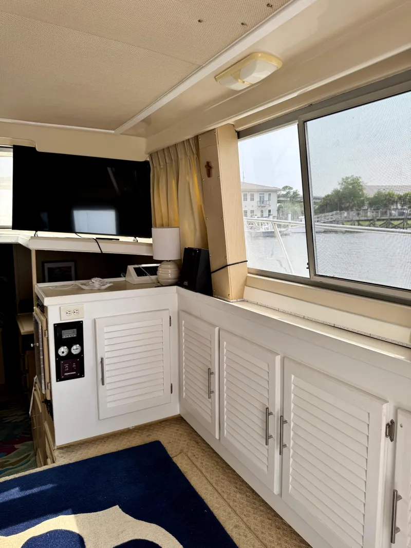 Slide: The Image of Interior of 1986 Silverton 34 Convertible Flybridge with cabinets and window view. - 22