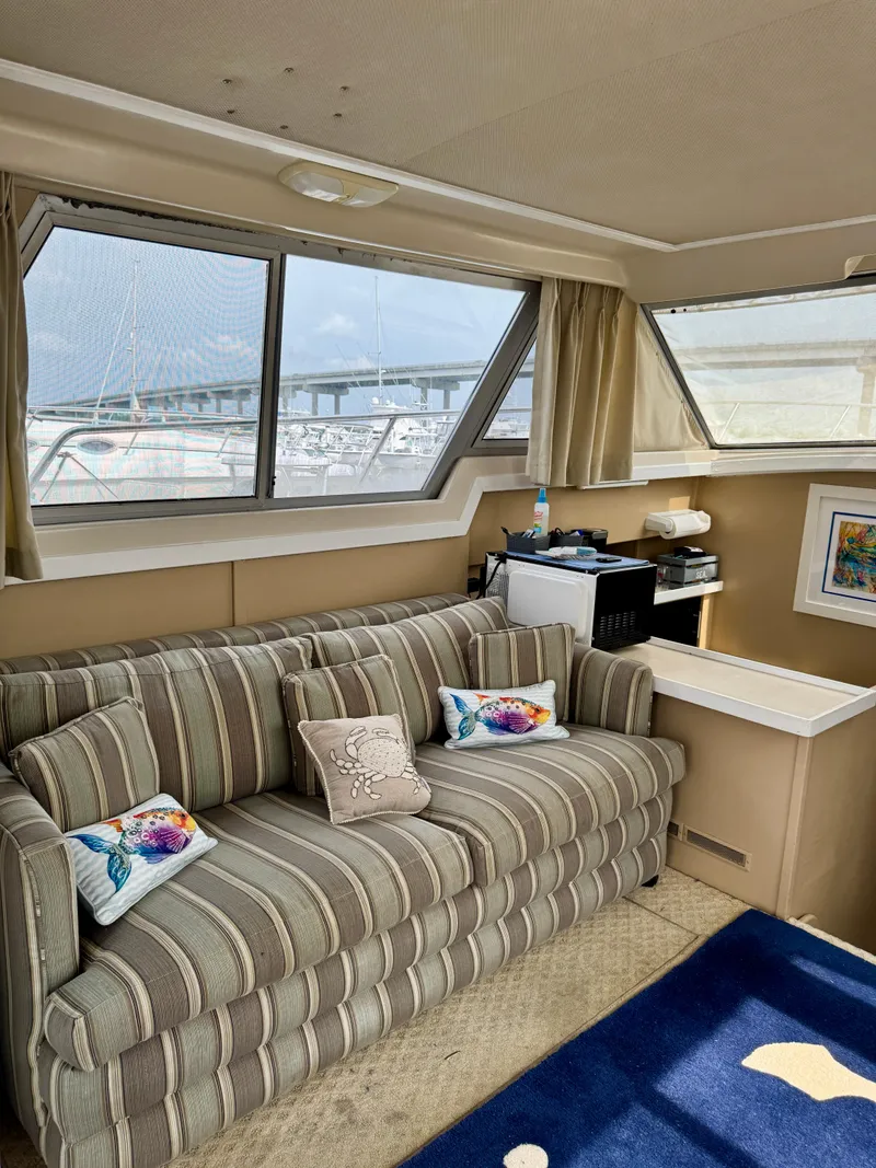 Slide: The Image of Interior of 1986 Silverton 34 Convertible Flybridge with striped sofa and nautical decor. - 23